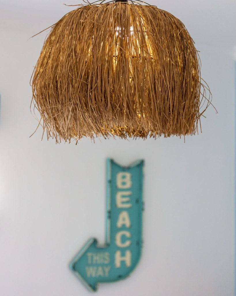 This way to the beach bue sign and rattan ibiza style lighting 