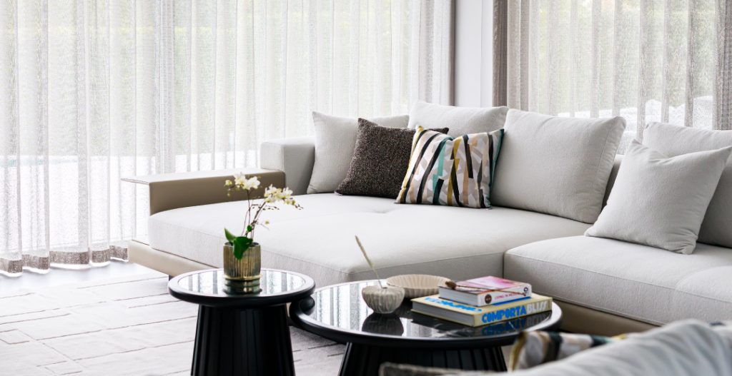 Bespoke living room sofa with dark wood decative coffee tables and geometric soft furnishings