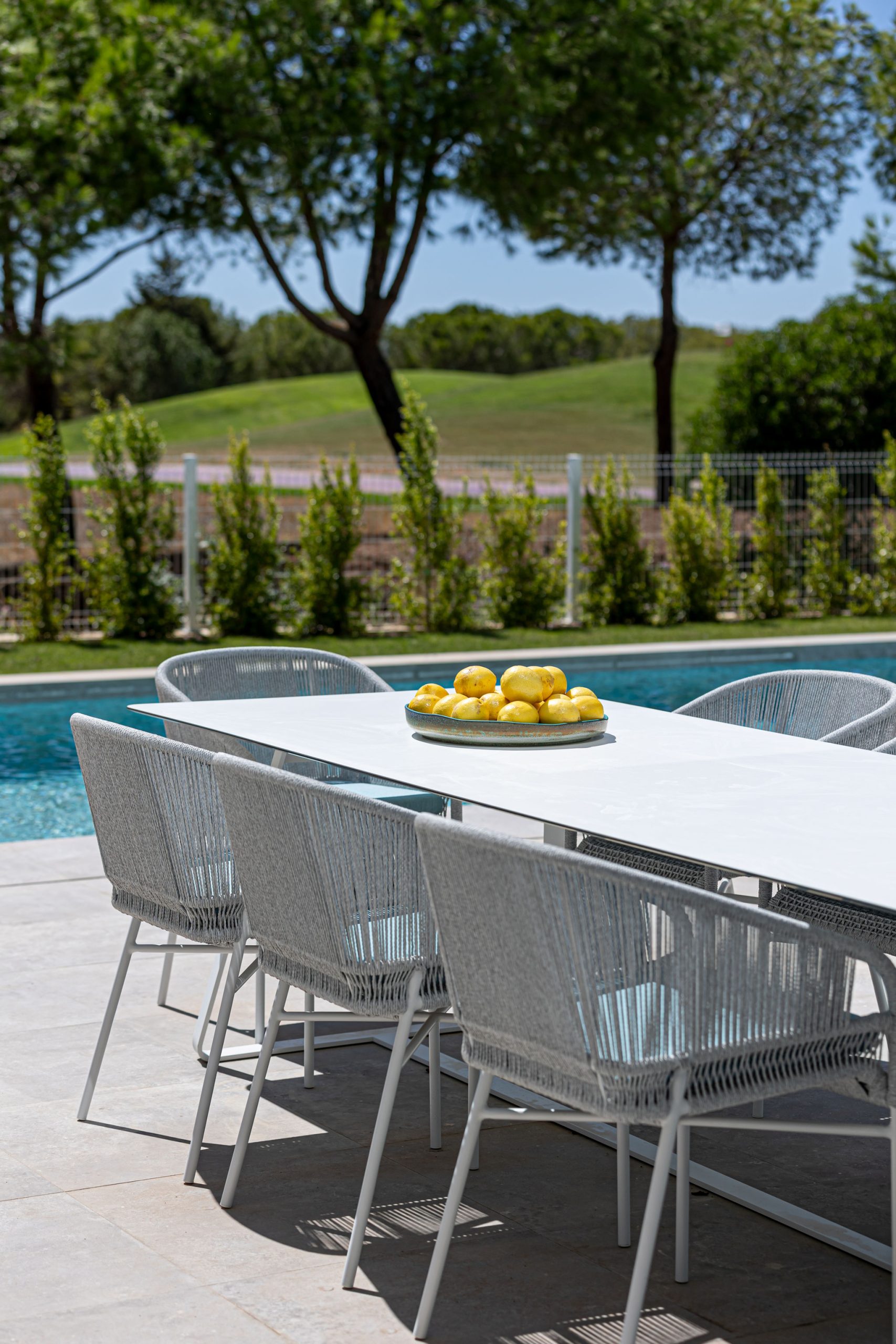 Outdoor premium brand dining table with woven chairs and golf course views